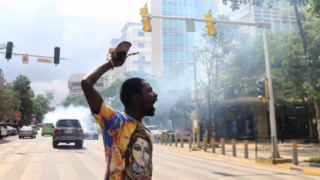 An activist reacts after riot police officers lobbed teargas canisters to disperse them