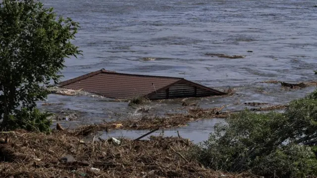 The roof of a house is seen in the Dnipro river, which flooded after the Nova Kakhovka