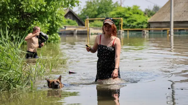 Local residents walk in a flooded street