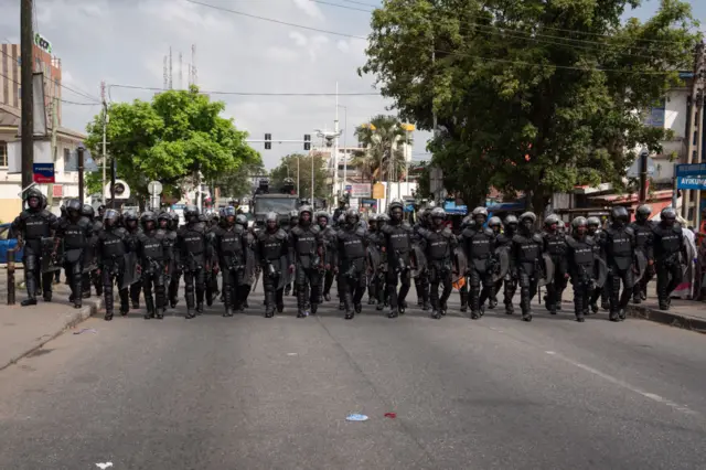 Police officers in riot gear stand guard during the "Ku Me Preko" demonstration on November 5, 2022, in Accra, Ghana