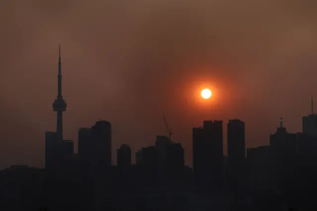 Smoke from forest fires in Northern Ontario and in Quebec contribute to pink hazy sunset in the city from the Cherry Beach over Toronto.