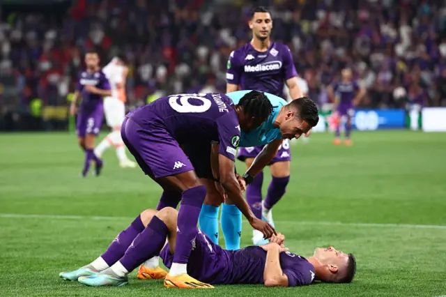 Fiorentina player down getting help from a team mate