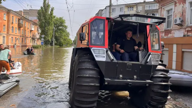 A vehicle drives through flood water