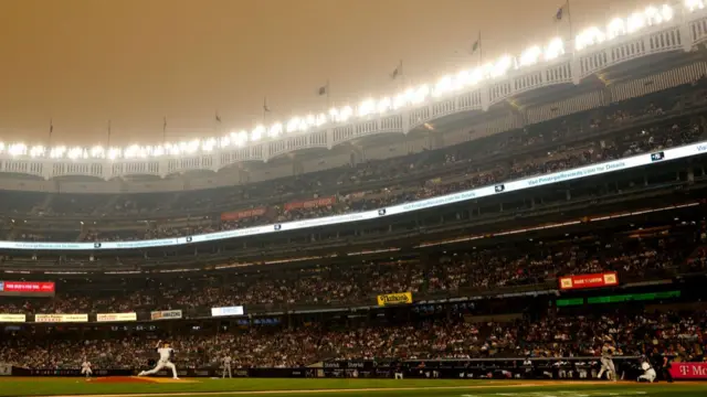 A dark haze lingers as Clarke Schmidt of the New York Yankees pitches during the first inning against the Chicago White Sox at Yankee Stadium on 6 June in the Bronx borough of New York City.