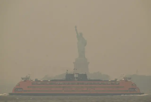 The Downtown Manhattan skyline stands shrouded in a reddish haze as a result of Canadian wildfires