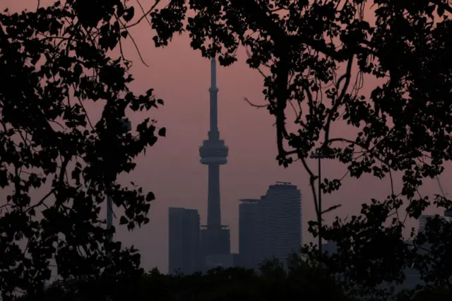 Smoke from forest fires in Northern Ontario and in Quebec contribute to pink hazy sunset in the city from the Cherry Beach over Toronto on 6 June