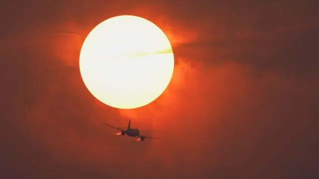 A plane flying through smoke haze