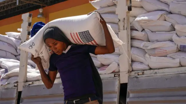 Volunteers at the Zanzalima Camp unload wheat flour, part of an aid delivery from USAid, Bahir Dahr, Ethiopia - December 2021