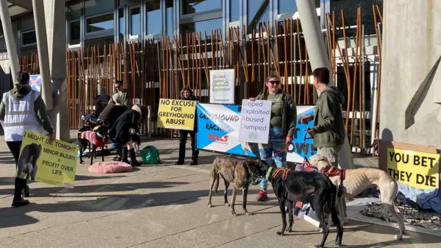 Anti-greyhound racing protestors gathered outside Scottish parliament with greyhound dogs and placards