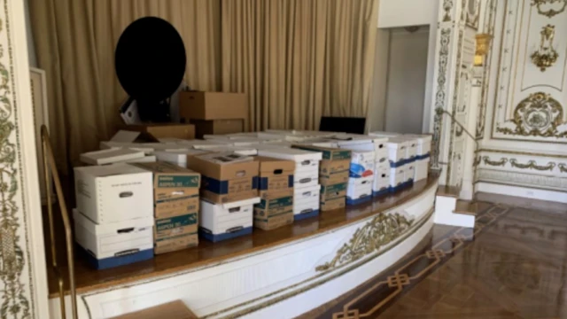 Rows of boxes stored on a stage in a grand room