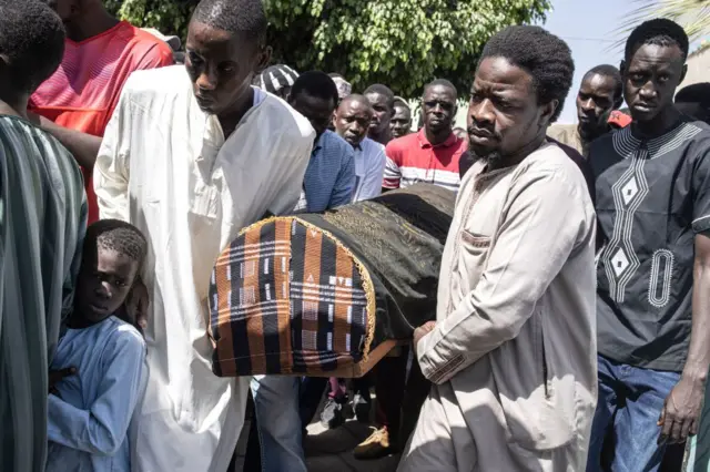 Friends and family of Doudou Diene, who was allegedly killed by a live round during last weeks protests, carry his coffin during his burial in Bargny on June 6, 2023.