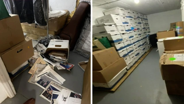 Documents spilling out of a box and across a floor on the left, and dozens of boxes stacked on top of each other on the right