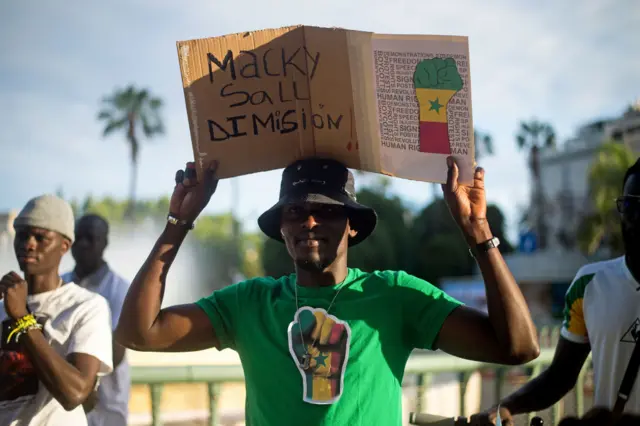 A protester is seen holding a placard during a protest calling on  Senegal's current president, Macky Sall, to step down.