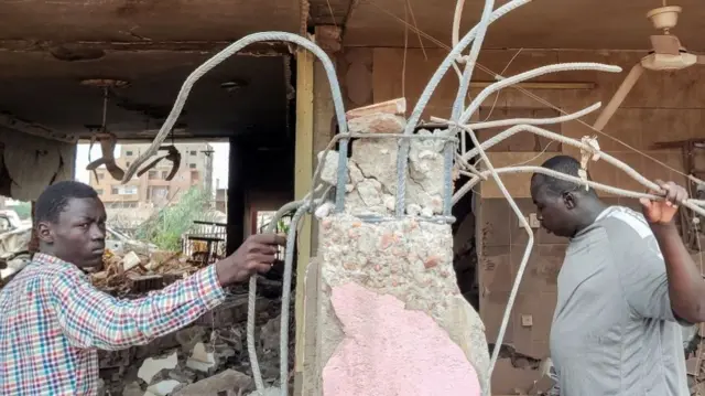 People inspect the rubble at a house that was hit by an artillery shell in the Azhari district in the south of Khartoum, Sudan -  6 June 2023