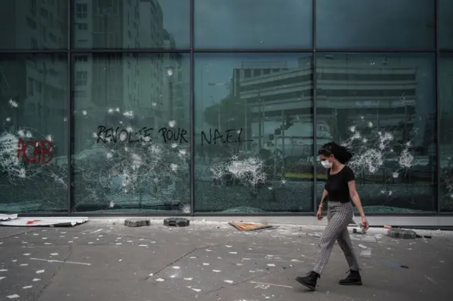 A woman walks past by a government office in Nanterre on 29 June 2023