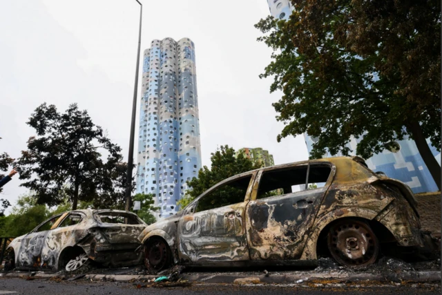 Burned out cars in front of block of flats