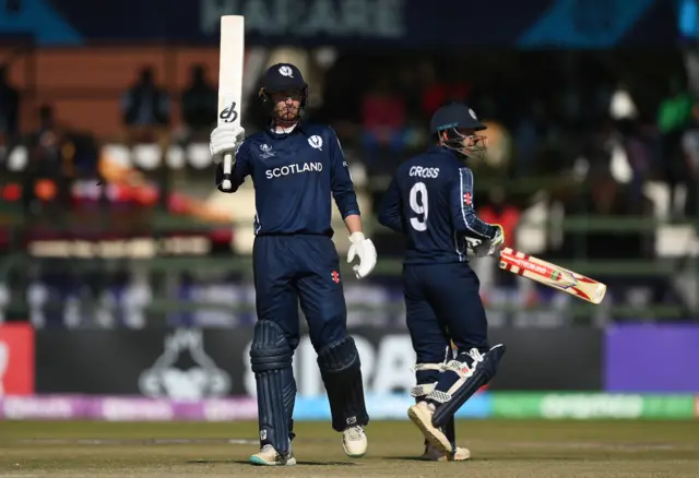 Brandon McMullen raises his bat to celebrate his latest 50