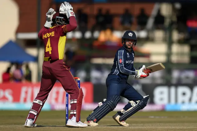 Shai Hope watches Matthew Cross play a shot away