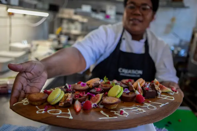 A chef displays a dessert platter.