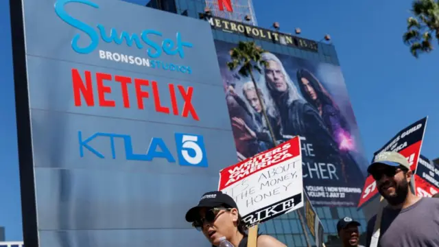 Striking Writers Guild of America (WGA) members walk the picket line in front of Netflix offices