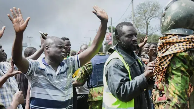 Supporters of Kenya's opposition leader Raila Odinga of the Azimio La Umoja (Declaration of Unity) One Kenya Alliance, talk to riot police officers as they participate in an anti-government protest against the imposition of tax hikes by the government, in Kisumu county, Kenya July 12