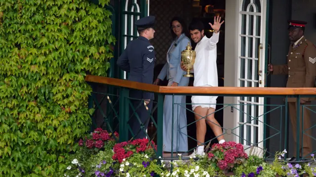 Carlos Alcaraz waves to spectators at Wimbledon