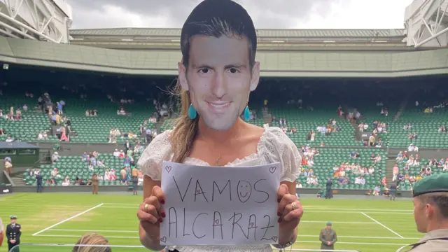 Fan with Djokovic mask and Alcaraz sign