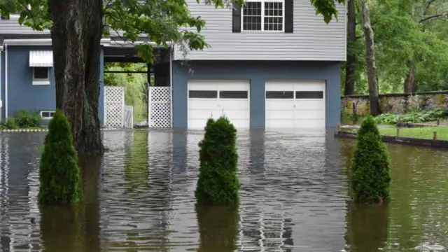 Vehicles drive through heavy flooding on roadways as houses go underwater in Hope Township, New Jersey, United States on July 16, 2023