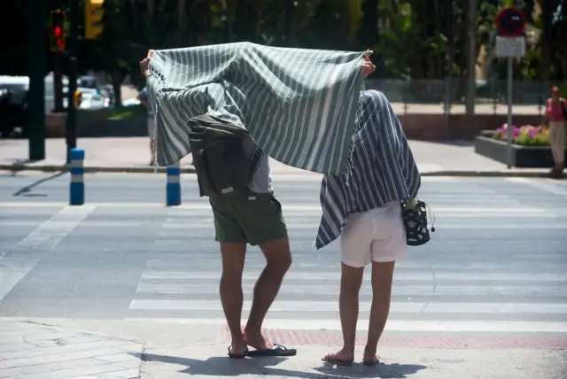 Tourists in Malaga with towels over their heads