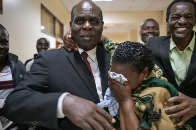 Gilbert Deya outside the courtroom with his followers