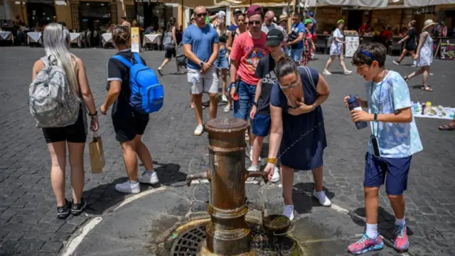 People queue for water during an ongoing heat wave with temperatures reaching 45 degrees, at Piazza del Pantheon, on July 18, 2023 in Rome, Italy.