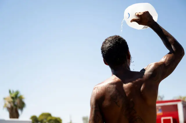 A person cools off in the searing heat, in Phoenix, Arizona.