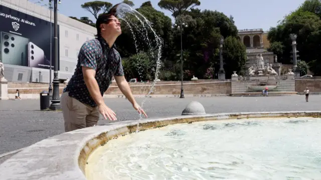 A man cools off at a fountain in Rome