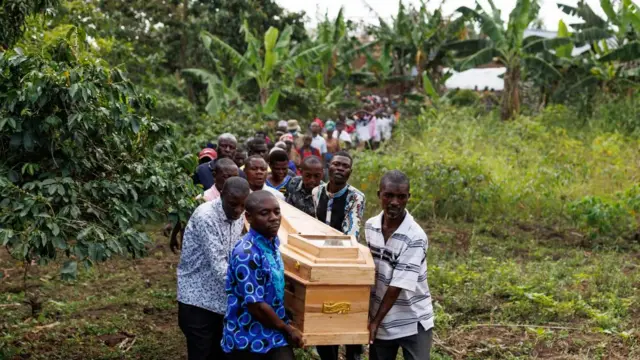 People carry the coffin of one of the victims of an attack at a school in Mpondwe, Uganda - 18 June 2023