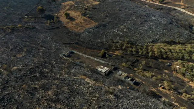 A burned property is seen in a charred area following a wildfire in Kouvaras