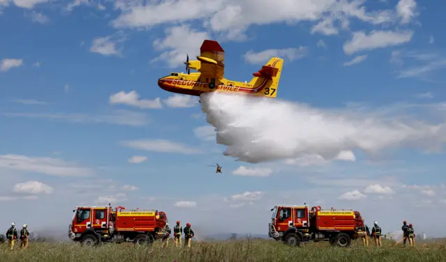 A Canadair CL-415 aircraft drops water during during a presentation exercise in France