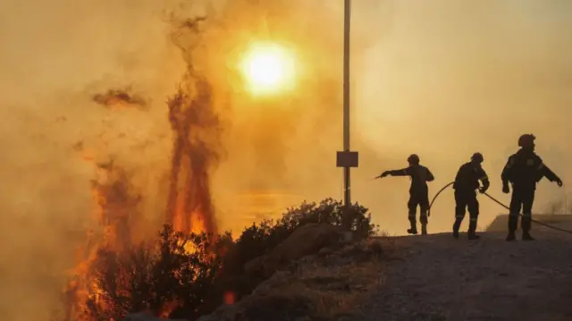 Firefighters attempt to tackle a blaze that has broken out in Greece