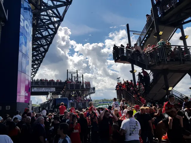 Fans greet the arrival of the team buses