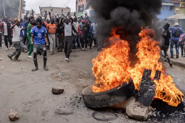 Opposition supporters gather in front of a burning barricade as they chant slogans against the Kenyan government during protests against the high cost of living in Nairobi, Kenya on July 19, 2023.