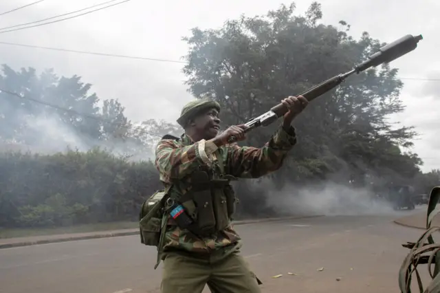 A Kenyan security officer prepares to fire a teargas cannister at demonstrators during an anti-government protest in Kibera, Nairobi, on July 19, 2023