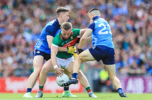 Ryan O'Donoghue is tackled by Eoin Murchan and Brian Howard