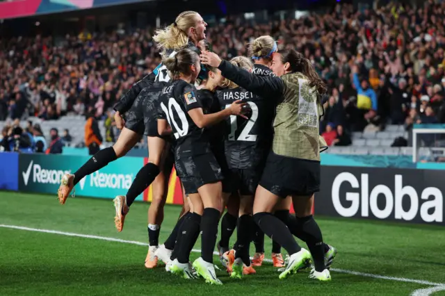 New Zealand players celebrate with the fans after the opening goal.