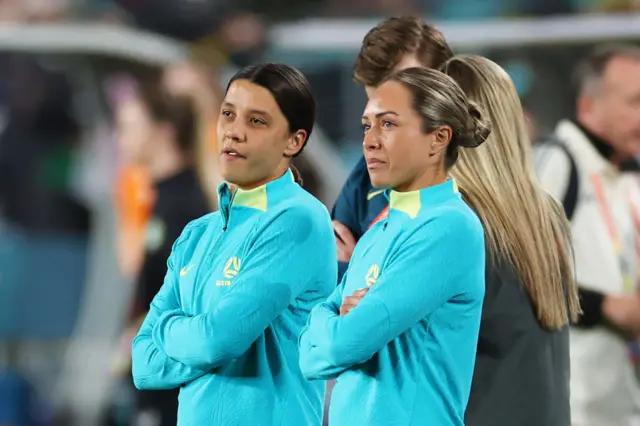 Sam Kerr and Kyah Simon watch on as their teammates warm up.