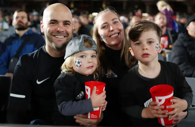 A young New Zealand supporting family patiently await kick off.