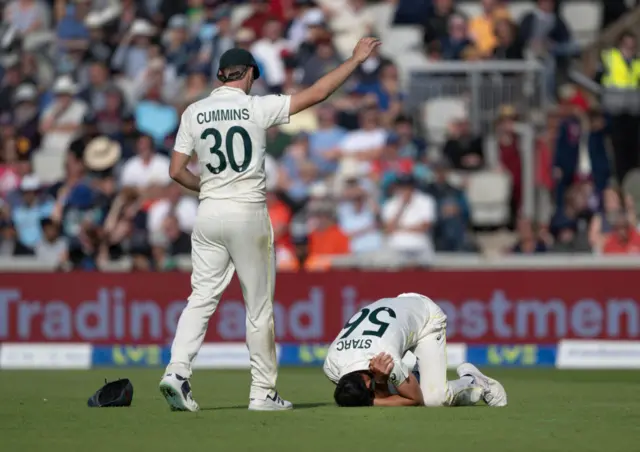 Mitchell Starc holding his shoulder in pain