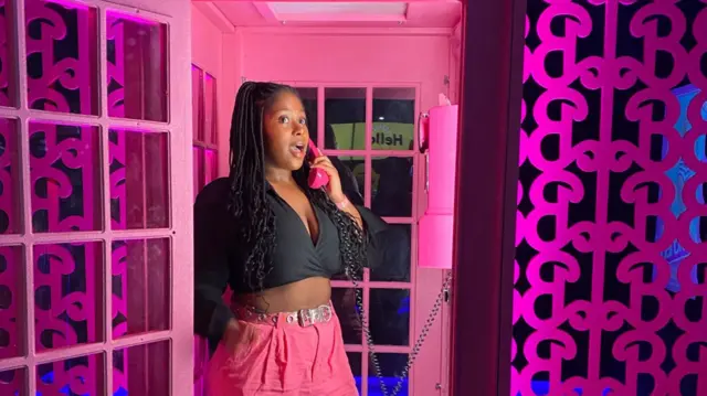 Kesewaa poses in a Barbie telephone box