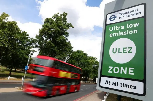 Stock image of a bus passing a ULEZ sign in London