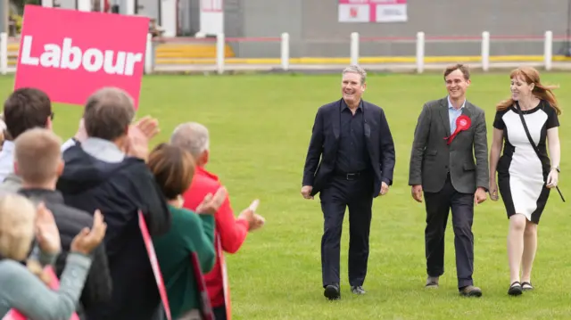 Newly elected Labour MP Keir Mather (centre), with Labour leader Sir Keir Starmer and deputy Labour Party leader Angela Rayner at Selby Town Football Club, North Yorkshire