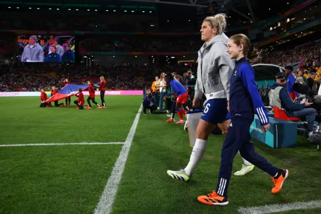 Millie Bright leads the England team out onto the pitch.