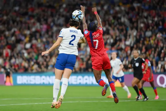 A Haitian defender raises her hands to connnect to the ball.